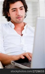 attractive young man browsing the internet at home