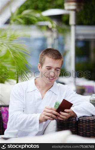 Attractive young man gets the money in a cafe