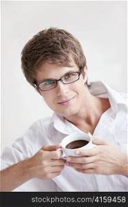 Attractive young man holding a cup of coffee