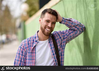 Attractive young man laughing outdoors. Lifestyle concept.. Attractive young man laughing outdoors. Funny guy wearing casual clothes in urban background. Lifestyle concept.
