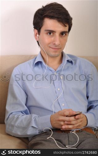 attractive young man listening to music on the couch
