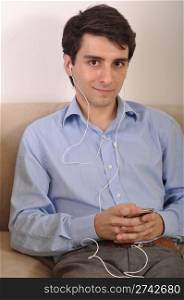 attractive young man listening to music on the couch