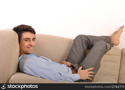 attractive young man lying and relaxing on the couch (isolated on white background)