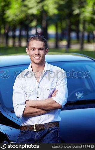 Attractive young man standing by car