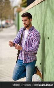 Attractive young man standing in urban background. Lifestyle con. Attractive young man standing in urban background. Guy wearing casual clothes. Lifestyle concept.