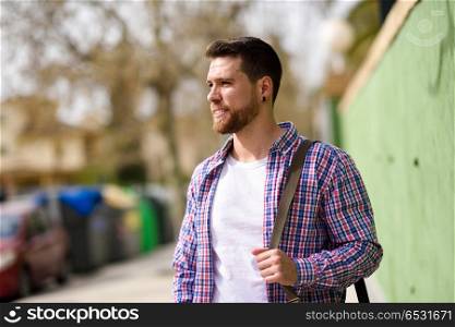 Attractive young man standing in urban background. Lifestyle con. Attractive young man standing in urban background. Guy looking away wearing casual clothes. Lifestyle concept.