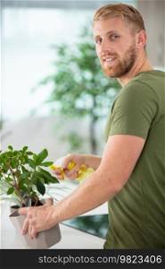 attractive young man watering plants