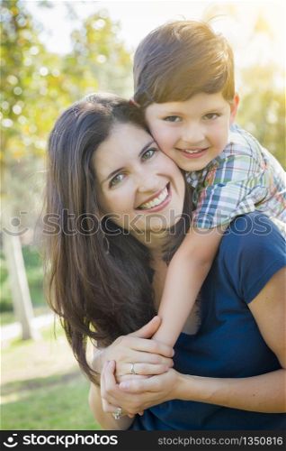 Attractive Young Mixed Race Mother and Son Hug Outdoors in the Park.