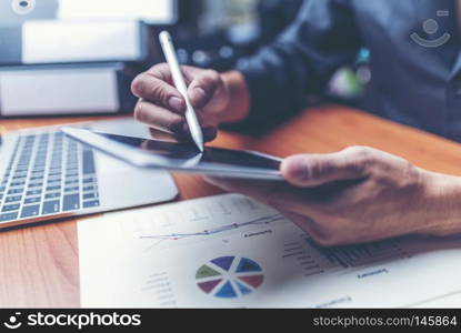 Attractive Young Office businessman Working on the Business Papers While Leaning on him Desk.