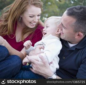 Attractive Young Parents Laughing with their Child Boy in the Park.