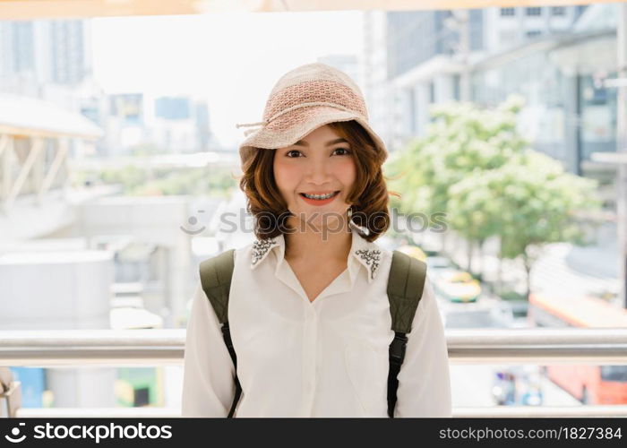 Attractive young smiling Asian woman outdoors portrait in the city real people series. Outdoors lifestyle fashion portrait of happy smiling Asian girl. Summer outdoor happiness portrait concept.