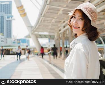 Attractive young smiling Asian woman outdoors portrait in the city real people series. Outdoors lifestyle fashion portrait of happy smiling Asian girl. Summer outdoor happiness portrait concept.
