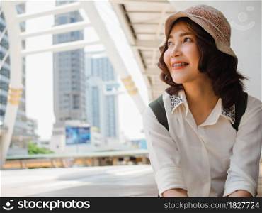 Attractive young smiling Asian woman outdoors portrait in the city real people series. Outdoors lifestyle fashion portrait of happy smiling Asian girl. Summer outdoor happiness portrait concept.
