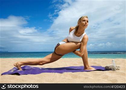 Attractive Young Woman Doing Yoga on Beach