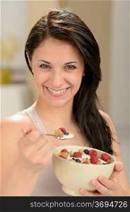 Attractive young woman eating a healthy bowl of cereal
