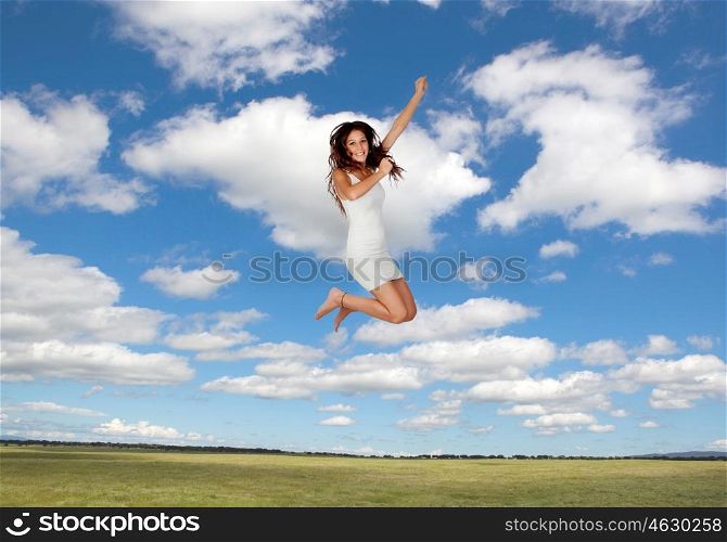 Attractive young woman jumping on a beautiful landscape with a blue sky