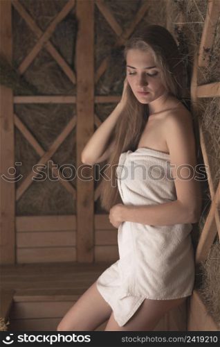 attractive young woman leaning wooden herbal wall