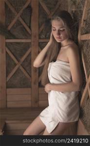 attractive young woman leaning wooden herbal wall