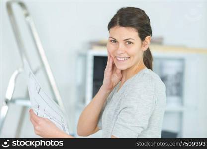attractive young woman looking at house plans