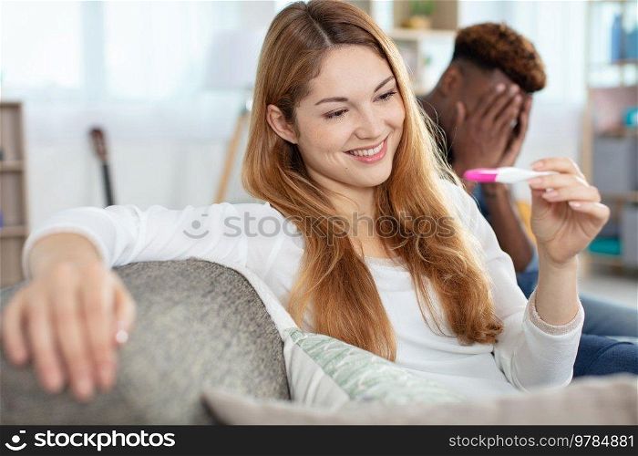 attractive young woman looking at pregnancy test