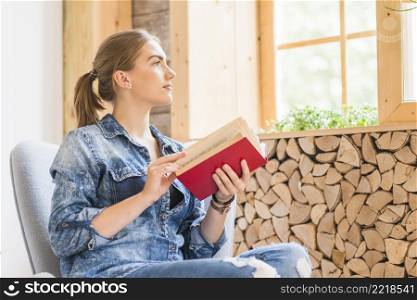 attractive young woman looking window with holding book
