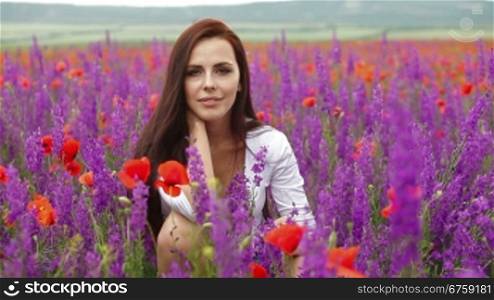 Attractive young woman posing in blossoming field