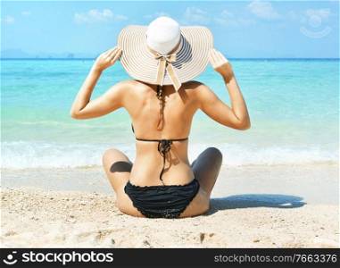 Attractive young woman relaxing and loking at the clear ocean