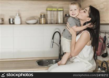 attractive young woman sitting kitchen counter loving her son