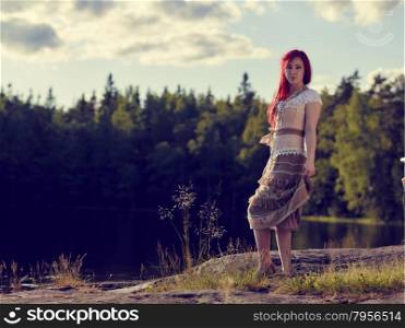 Attractive young woman wearing a dress, summer day on the lake