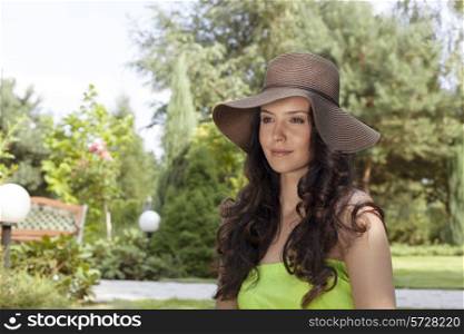 Attractive young woman wearing sunhat in park