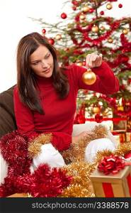 Attractive young woman with Christmas decoration in front of tree