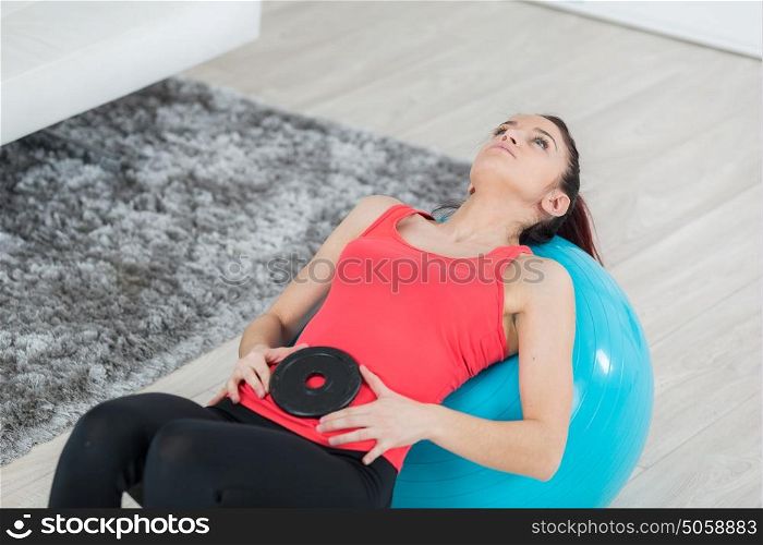 attractive young woman working out with fitness ball indoors