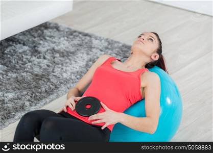 attractive young woman working out with fitness ball indoors