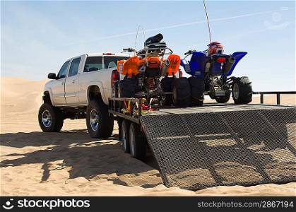 ATVs on Trailer Behind Pickup Truck