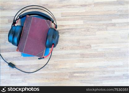 Audio book concept. Black headphones and books on wooden table. Top view with copy space.. Audio book concept