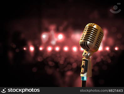 audio microphone retro style. Single retro microphone against colourful background with lights