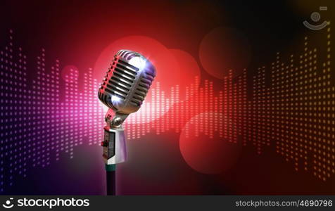 audio microphone retro style. Single retro microphone against colourful background with lights