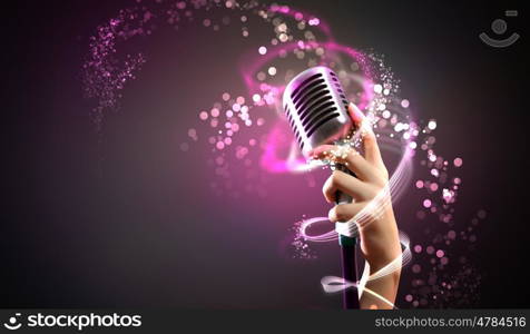 audio microphone retro style. Single retro microphone against colourful background with lights