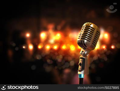 audio microphone retro style. Single retro microphone against colourful background with lights