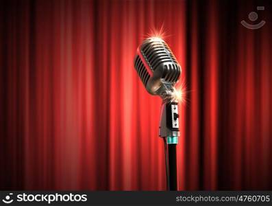 audio microphone retro style. Single retro microphone against red curtains closed on the background