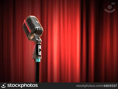 audio microphone retro style. Single retro microphone against red curtains closed on the background