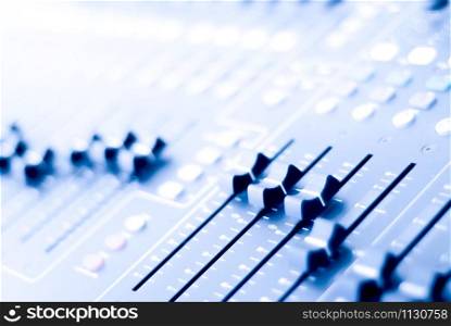 Audio mixer control panel view with sliders. Audio mixer in blur.