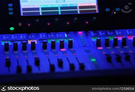 audio mixer in blue light lamps faders and touchscreen in a theater. audio mixer in blue light lamps faders and touchscreen