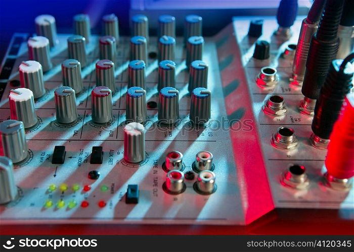 Audio mixer music desk under colorful lights