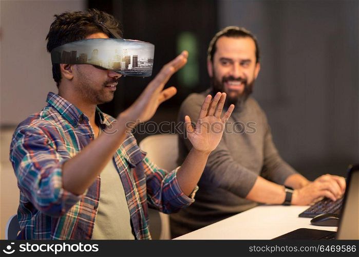augmented reality and technology concept - developers with singapore city on virtual headset or 3d glasses screen working late at night office. developers with virtual reality headset at office
