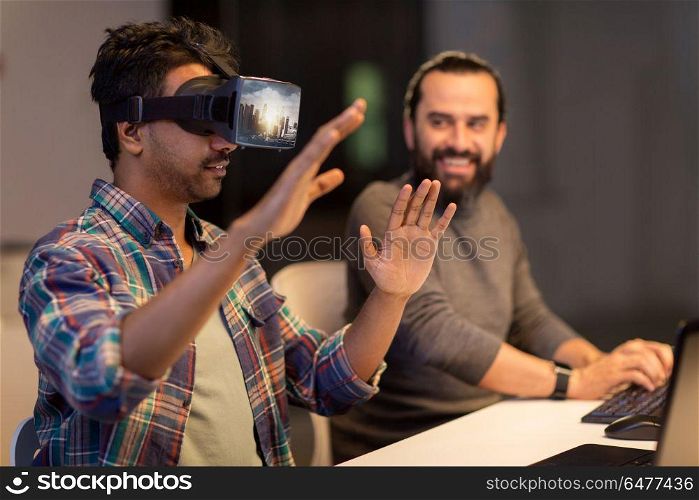 augmented reality and technology concept - developers with singapore city on virtual headset or 3d glasses screen working late at night office. developers with virtual reality headset at office. developers with virtual reality headset at office