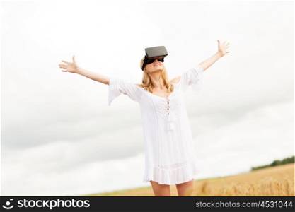 augmented reality, gaming, summer holidays, technology and people concept - happy young woman with virtual reality headset or 3d glasses on cereal field with raised hands