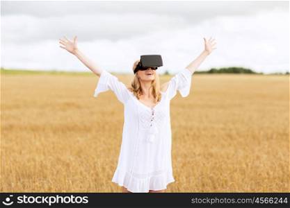 augmented reality, gaming, summer holidays, technology and people concept - happy young woman with virtual reality headset or 3d glasses on cereal field with raised hands