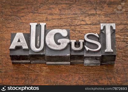 August word in mixed vintage metal type printing blocks over grunge wood