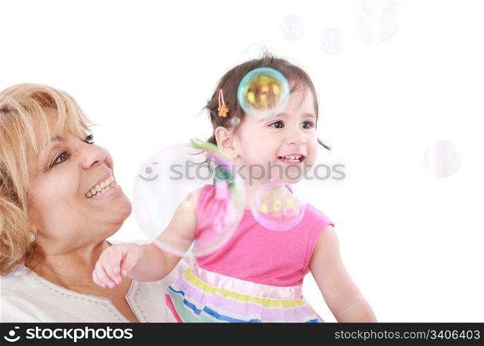 Aunt and a little girl enjoy looking at bubbles floating in the air